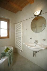 a bathroom with a sink and a mirror and a tub at Ferienhaus Aussergraben in Ultimo