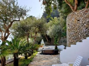 un patio avec une table, des chaises et des arbres dans l'établissement La Limonaia e La Praia, à Praiano