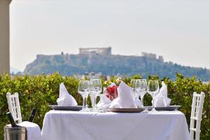 een witte tafel met wijnglazen en servetten erop bij Crystal City Hotel in Athene