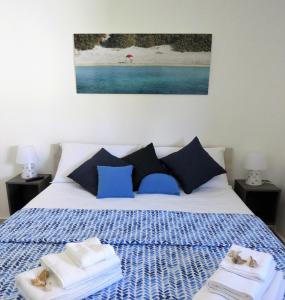 a bedroom with a bed with blue and white sheets and towels at B&B Vento del Mare in San Pietro in Bevagna