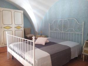 ジョヴィナッツォにあるSecret Gardenのベッドルーム1室(白いベッド1台、青い壁付)