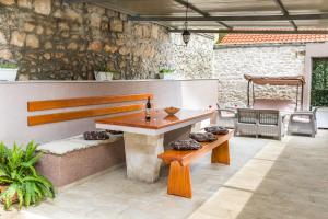 a patio with a wooden table and benches on a patio at Royal Fortune in Brna