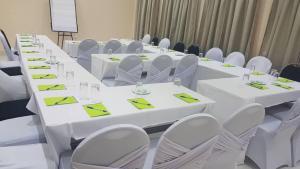 a long table with white tables and chairs in a room at Wadonda Suites in Zomba
