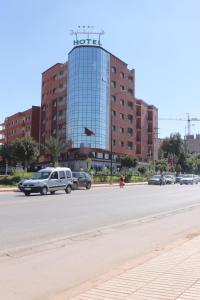 un grande edificio con un cartello sopra di Hôtel Hadaik Ain Asserdoune a Beni Mellal