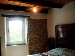 een slaapkamer met een bakstenen muur en een raam bij Ca' Morano in Pavullo nel Frignano