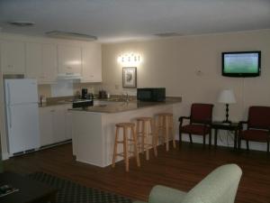 a kitchen and living room with a bar and chairs at Merry Acres Inn in Albany