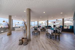 a restaurant with tables and chairs and large windows at Holiday Club Puerto Calma in Puerto Rico de Gran Canaria
