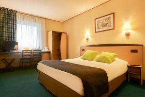 a hotel room with a large bed with yellow pillows at Campanile Hotel Szczecin in Szczecin