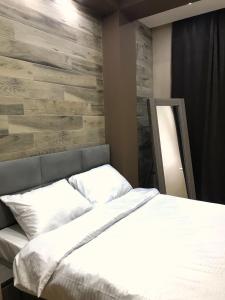 a bedroom with a bed and a wooden wall at Luxury 4-Bedroom Apartment In The Center in Tbilisi City