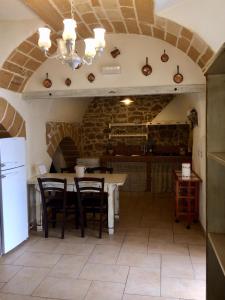 una cucina con un tavolo e sedie in una stanza di Palazzo Saraceno apartments-Antica mangiatoia a Taranto