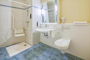 a bathroom with a toilet and a sink at Campanile Hotel Szczecin in Szczecin +15 photos