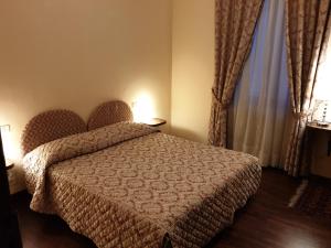 sypialnia z łóżkiem i dużym oknem w obiekcie Affittacamere Mazzini 78 w mieście Grosseto