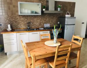 una cucina con un tavolo di legno con sedie e un lavello di Civico Vesuvio B&B a Napoli Altre 37 foto