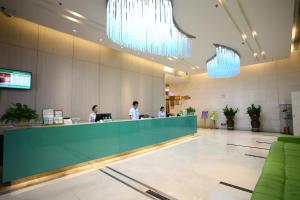 a lobby with two people working at a counter at Landscape Fashion Hotel Guangzhou East Station in Guangzhou