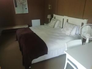 a bedroom with a large white bed with pillows at Point Lodge Knysna in Knysna