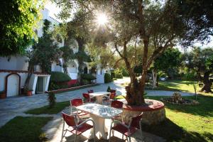 a patio with a table and chairs under a tree at Castello Verde Plakias in Plakias +15 photos