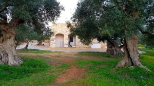 a stone building with trees in front of it at Piccante Seaview by LoveSud in Patù