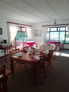 a dining room with tables and chairs with red tablecloths at Point Lodge Knysna in Knysna