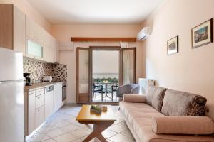 een keuken en een woonkamer met een bank en een tafel bij Katerina's Cozy Mountain View Apartment in Argostoli