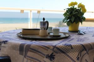 a table with a table cloth with a tea kettle and a plate at Alba sul Mare in Alba Adriatica