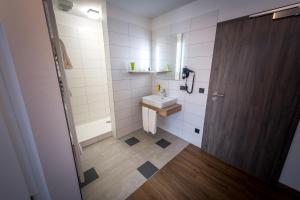 
a small bathroom with a sink, toilet, and cabinet at Hotel & Brauerei-Gasthof Neuwirt in Neuburg an der Donau
