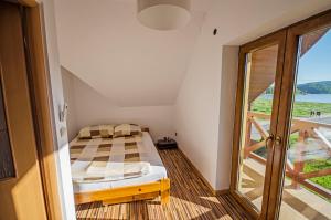 um pequeno quarto com uma cama e uma varanda em Domek Letniskowy Melon House em Gródek Nad Dunajcem