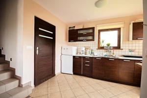 a kitchen with brown cabinets and a white refrigerator at Domek Letniskowy Melon House in Gródek Nad Dunajcem