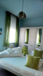 a large white bed in a bedroom with green curtains at Hotel Monte Somma in Rüdesheim am Rhein