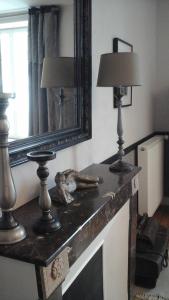 une table avec deux lampes et un miroir dans l'établissement Chambre d'hôte le 18-20, à Saint-Martin-des-Entrées