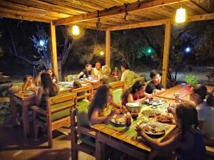 a group of people sitting at a table at night at KARABURUN KÖYEVİ Pansiyon in Saip