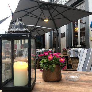 an umbrella and a candle on a table with flowers at Hotel Crasborn Thorn in Thorn