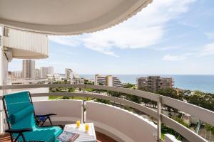 balkon z niebieskim krzesłem i oceanem w obiekcie Ocean View by Encantos do Algarve - 910 w mieście Portimão