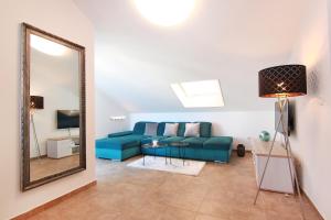 a living room with a blue couch and a mirror at Sky-apartment in Povljana