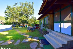 eine Veranda eines Hauses mit einem Tisch und Stühlen in der Unterkunft Villa Joe in Peqi‘in H̱adasha