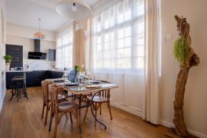 una cucina e una sala da pranzo con tavolo e sedie di Elégant appartement en plein coeur de Cabourg - Les locations de Proust a Cabourg