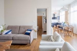 a living room with a couch and a table at Elégant appartement en plein coeur de Cabourg - Les locations de Proust in Cabourg