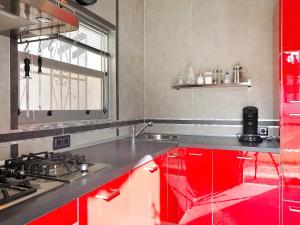 a kitchen with red cabinets and a sink at Holiday Home La Yaya by Interhome in Fanadix