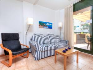 uma sala de estar com um sofá e uma cadeira em Apartment Gardenia by Interhome em Lloret de Mar