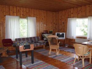 uma sala de estar com um sofá, uma mesa e cadeiras em Holiday Home Raanumaja ii by Interhome em Lampsijärvi