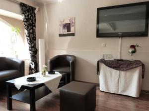 a waiting room with a table and a tv on the wall at Hotel Jägerhof in Mayen