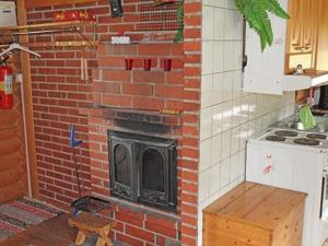 a brick fireplace with a stove in a kitchen at Holiday Home 6012 by Interhome in Suninsalmi