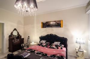 a bedroom with a bed and a chandelier at Apartment Evita in Sopot