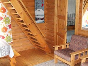 a wooden cabin with a staircase and a chair at Holiday Home 6012 by Interhome in Suninsalmi