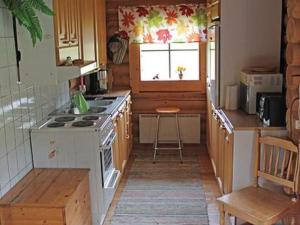 Il comprend une petite cuisine avec une cuisinière et une fenêtre. dans l'établissement Holiday Home 6012 by Interhome, à Suninsalmi
