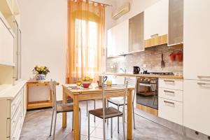 a small kitchen with a wooden table and chairs at Bologna Zanolini Apartment in Bologna