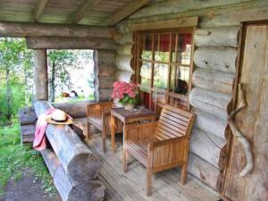 a porch of a log cabin with a table and chairs at Holiday Home Mäkitorppa by Interhome in Pätiälä
