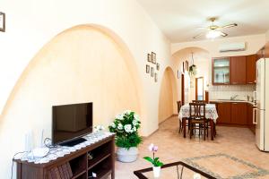 a living room with a tv and a kitchen at Doris House Sorrento in Sorrento