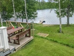 una terraza de madera con mesa de picnic junto a un lago en Holiday Home Villa elisabet by Interhome, en Löytö