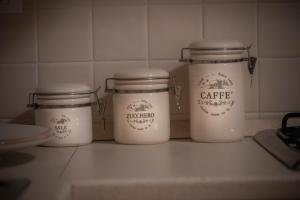 three white jars sitting on a kitchen counter at Doris House Sorrento in Sorrento