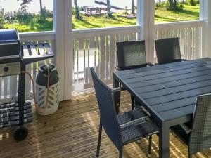 porche acristalado con mesa y sillas azules en Holiday Home Villa urho by Interhome, en Löytö